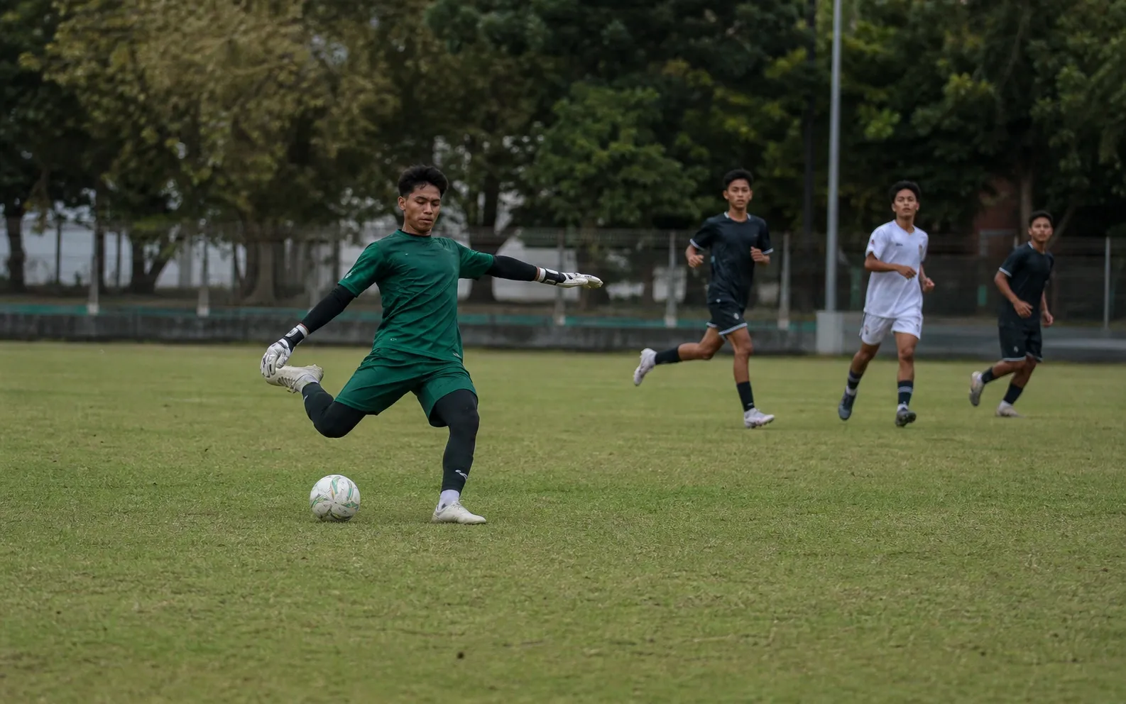 Kiper keluar dari kotak penalti untuk menyapu bola perlahan di lapangan
