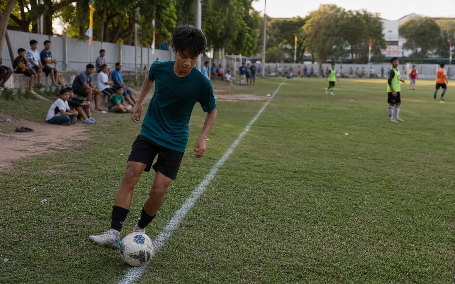 Pemain sayap berlatih mengontrol bola rapat di dekat garis lapangan