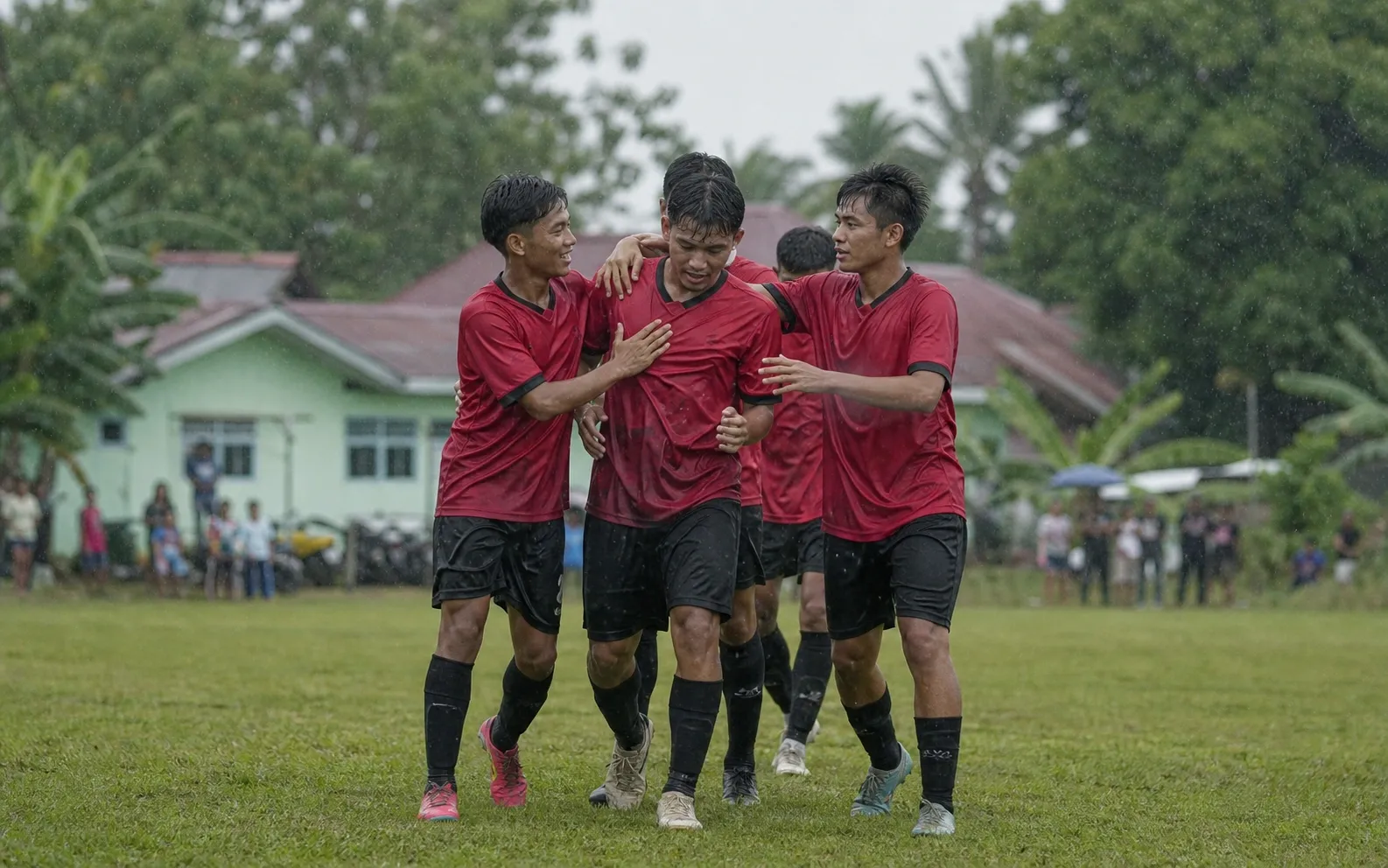 Rekan setim merayakan gol ketiga secara sederhana tanpa piala atau atribut merek